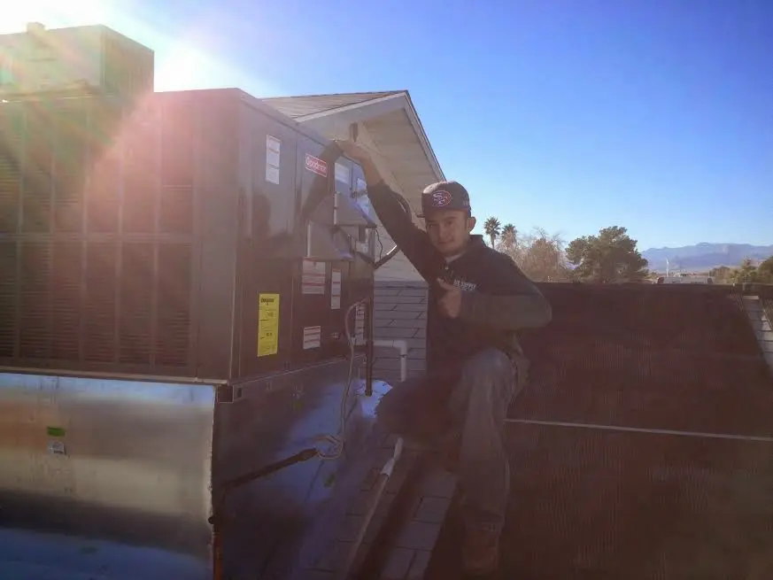 HVAC technician performing Heat Pump Repair on a rooftop unit in Malibu